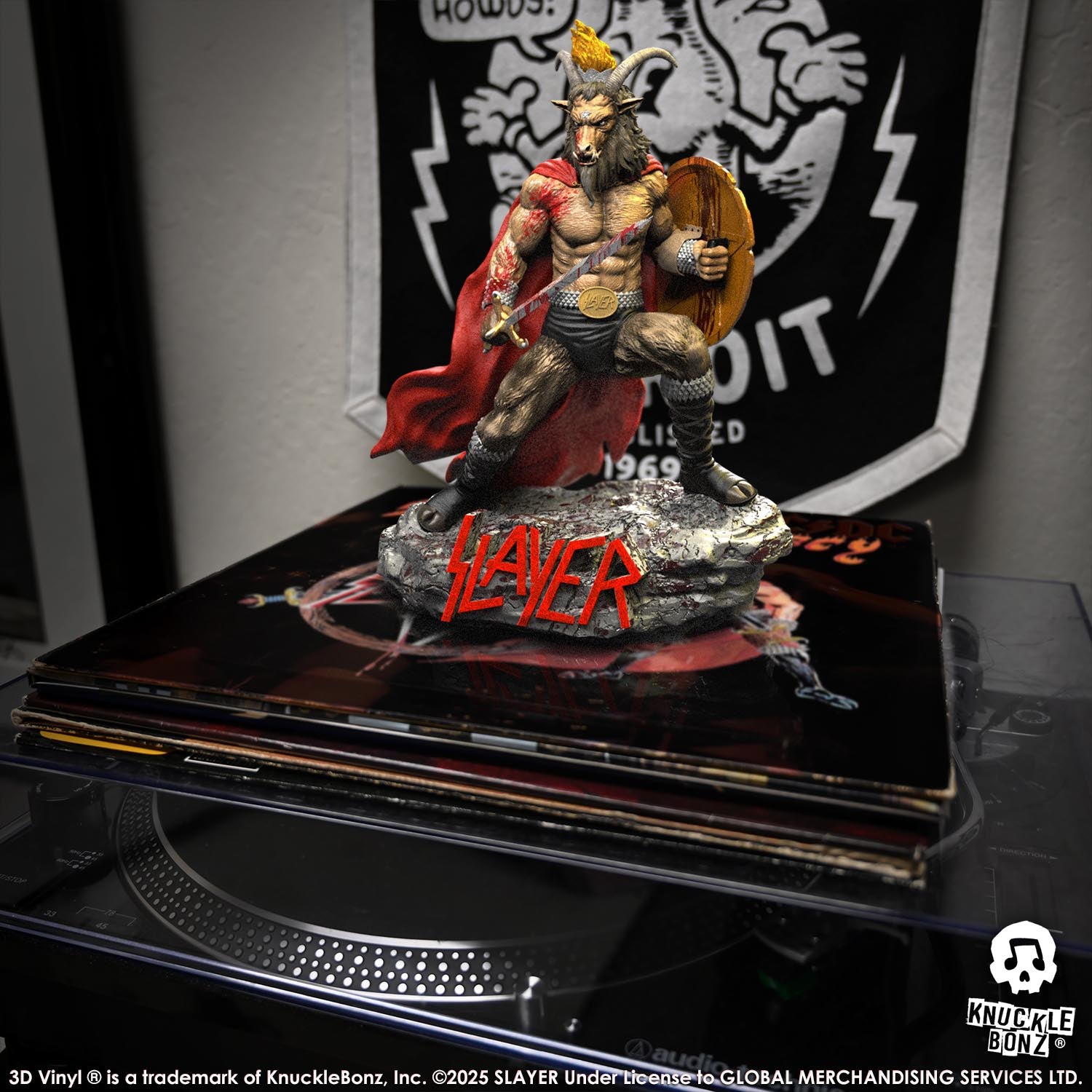 Statue of the Slayer Show No Mercy statue with a sword and shield, featuring the Slayer logo on a stack of albums